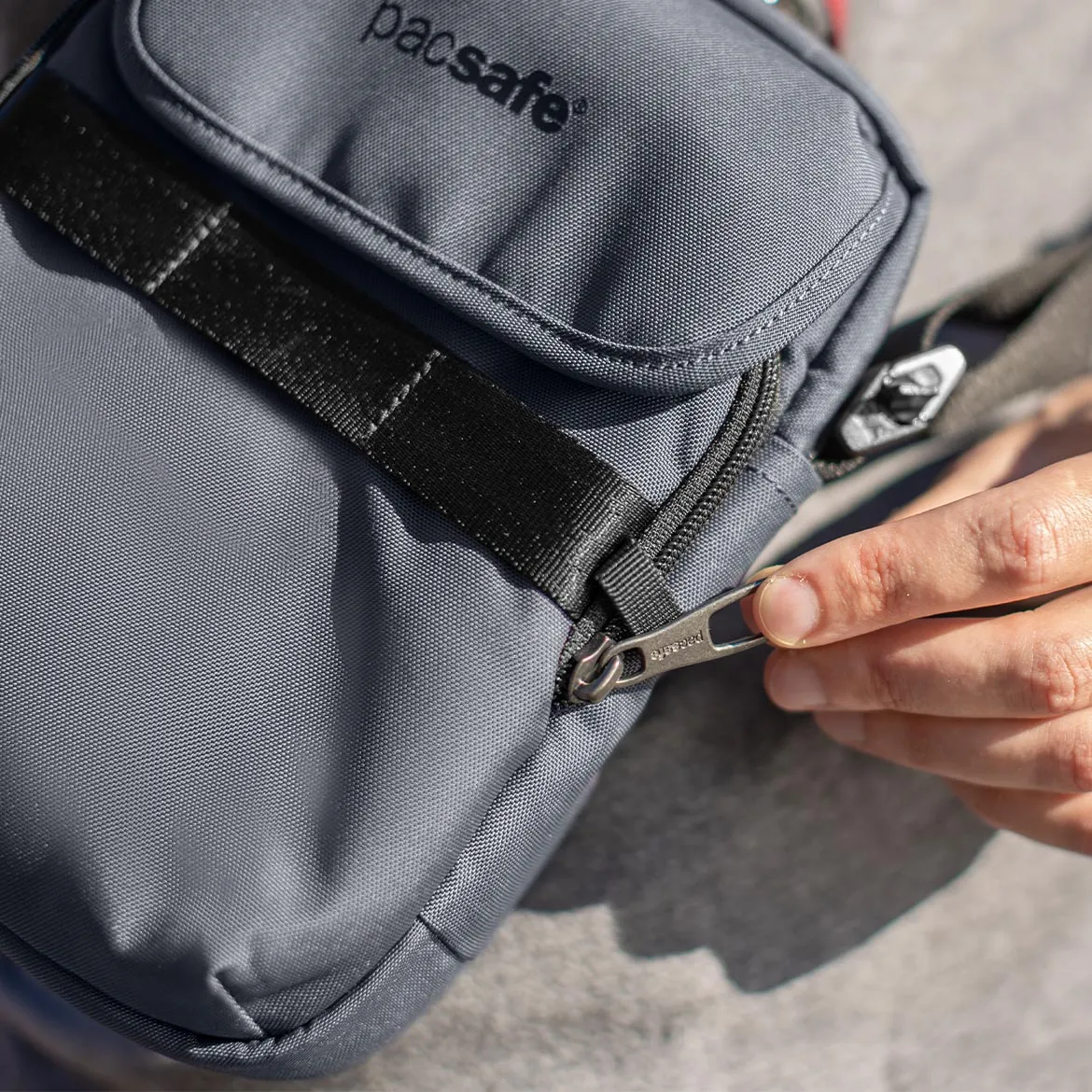 Torebka męska antykradzieżowa w kolorze szarym Pacsafe X z zabezpieczeniem zamka Zip Tab